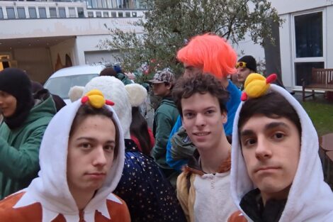 A group of young men are dressed in Halloween chicken costumes to distribute candy to children.